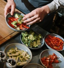 A professional chef prepares fresh vegetable plates in a modern kitchen setting.